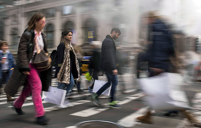 Shoppers carry their purchases as they walk though the steam coming from the underground along Fifth Avenue on Black Friday in New York, Friday, Nov. 25, 2016. Shoppers were on the hunt for deals and were at the stores for entertainment Friday as malls opened for what is still one of the busiest days of the year, even as the start of the holiday season edges ever earlier. (AP Photo/Andres Kudacki)