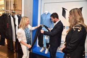 Ginny Hilfiger and Lionel Messi with clothing from his fashion line.