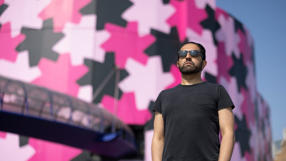 Osman Yousefzada in front of the Selfridges Birmingham covered with patterns designed by himself.
