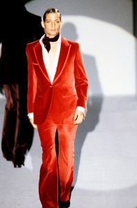 A model walks the runway in a red velvet suit from the Gucci fall 1996 RTW collection designed by Tom Ford.
