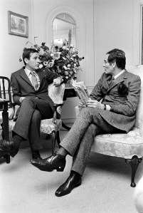 Designer Pierre Cardin with guest reading the Daily News Record (DNR).