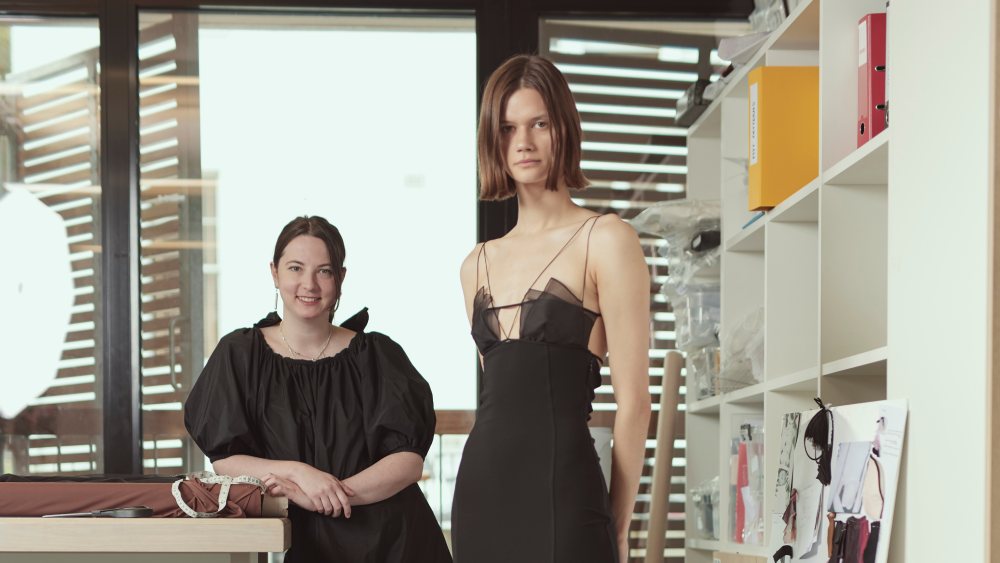 Nensi Dojaka with a model wearing her design in the studio