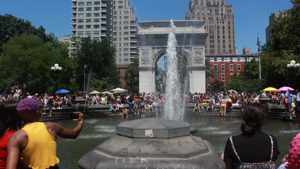 Explicatives denouncing SCOTUS are the focal point of Washington Square Park fountain where Pride-goers gather to cool off.