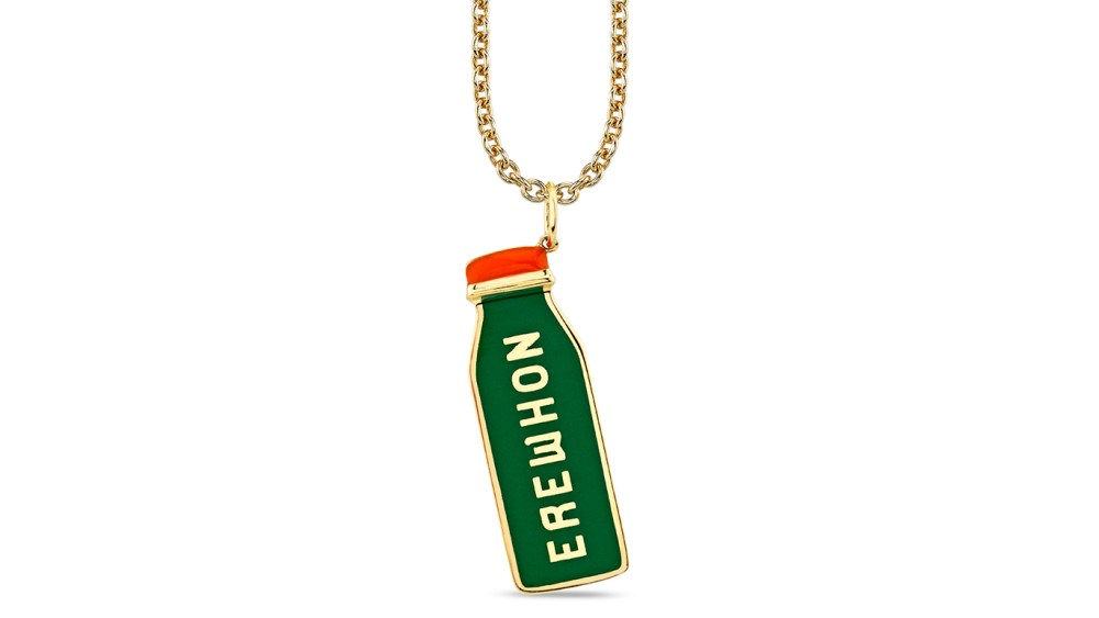 Sydney Evan X Erewhon necklace features a gold chain with a juice bottle-shaped pendant in green, with red cap and the text Erewhon.