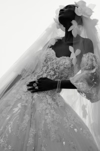 Morilee by Madeline Gardner’s A-line tulle ballgown with corset boned bodice, embroidered floral appliqués and wide horsehair hemline. Viktor & Rolf Marriage veil; Wempe diamond earrings, diamond chain bracelets and diamond ring; De Beers diamond rings.
