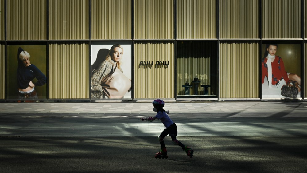 A child skates past advertising outside a mall in Beijing.