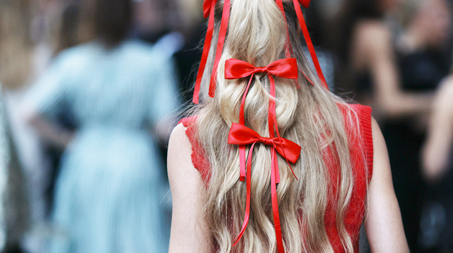 Woman with red bows in her hair after using heatless curl products