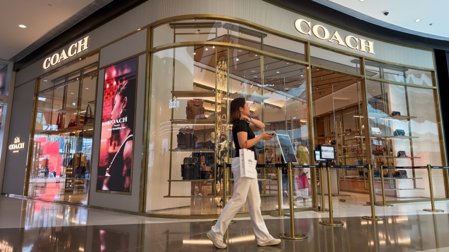 SANYA, CHINA - MARCH 5: A shopper walks past a Coach store at the Sanya International Duty Free Shopping Complex, also known as CDF Mall, on March 5, 2026 in Sanya, Hainan Province, China. The tropical island province launched island-wide customs closure operations for the Hainan Free Trade Port in December 2025, expanding duty-free policies and positioning the island as a major shopping destination for domestic tourists. (Photo by Cheng Xin/Getty Images)