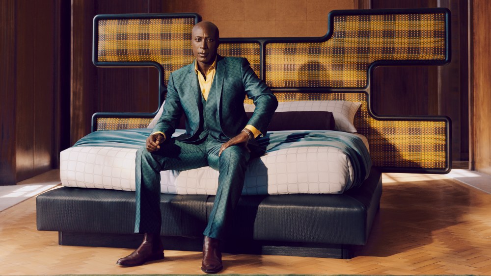 Ozwald Boateng sitting on his new design for Savoir Beds.